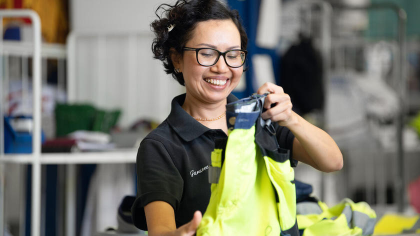Uśmiechnięta kobieta pracująca z ubraniami na wynajem